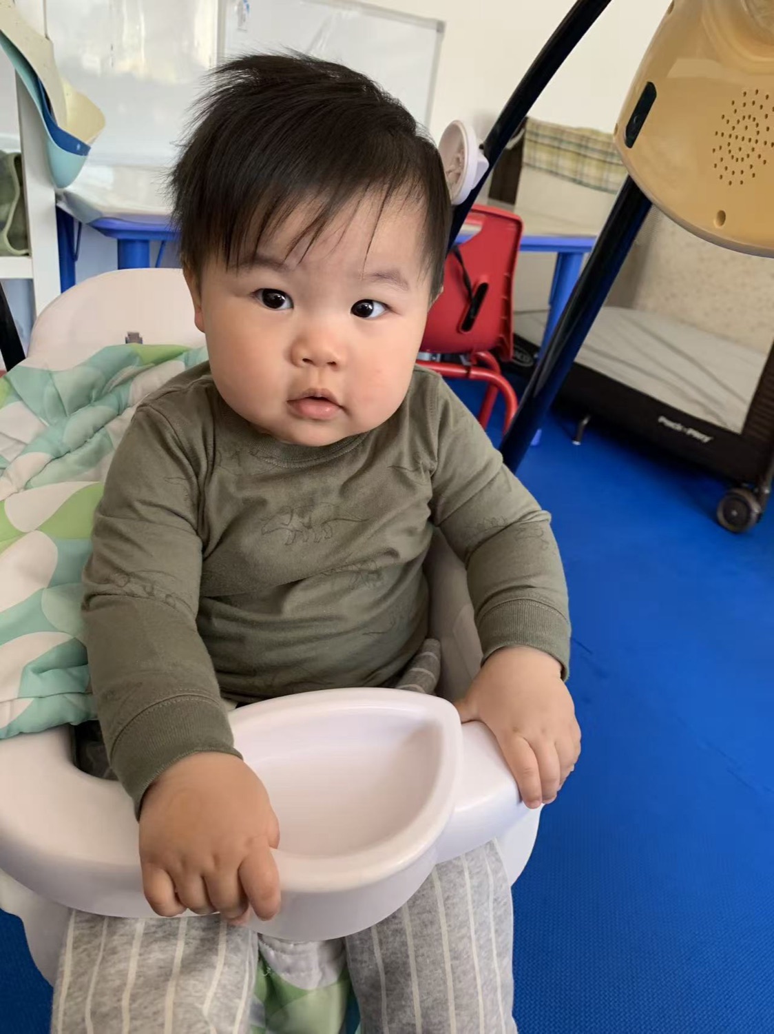 婴幼儿坐在安全餐椅中，环境温馨整洁
