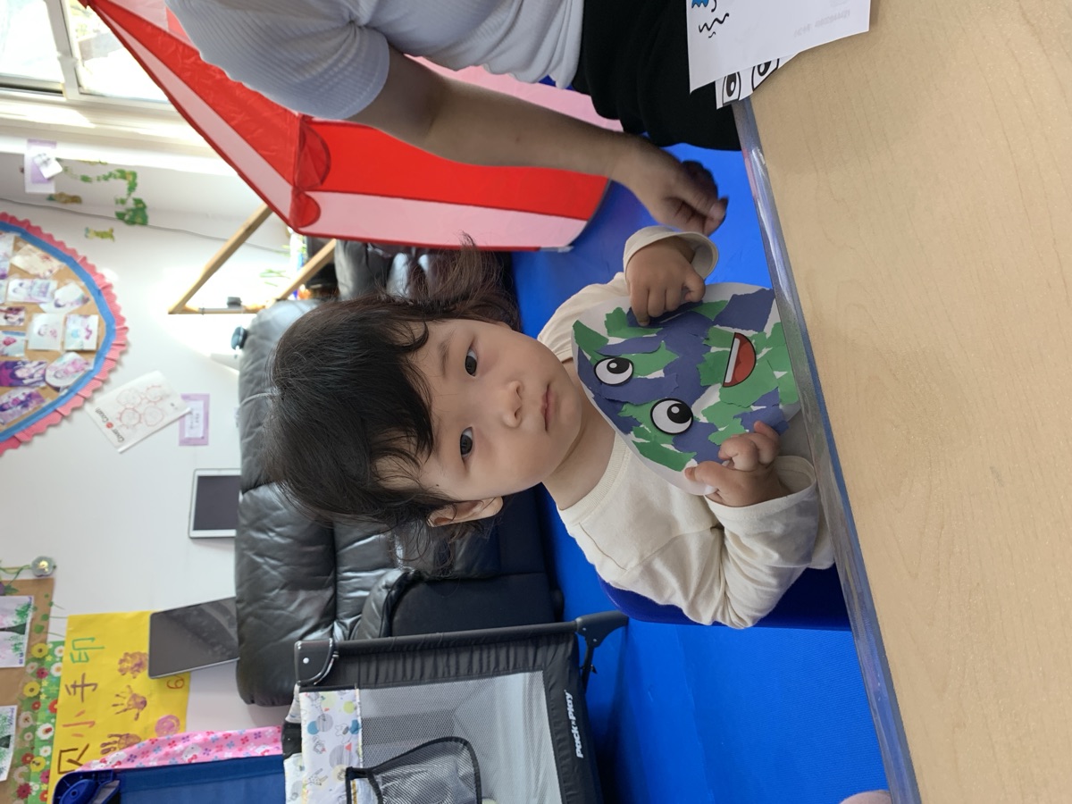 幼儿手拿地球日主题地球拼贴手工卡片