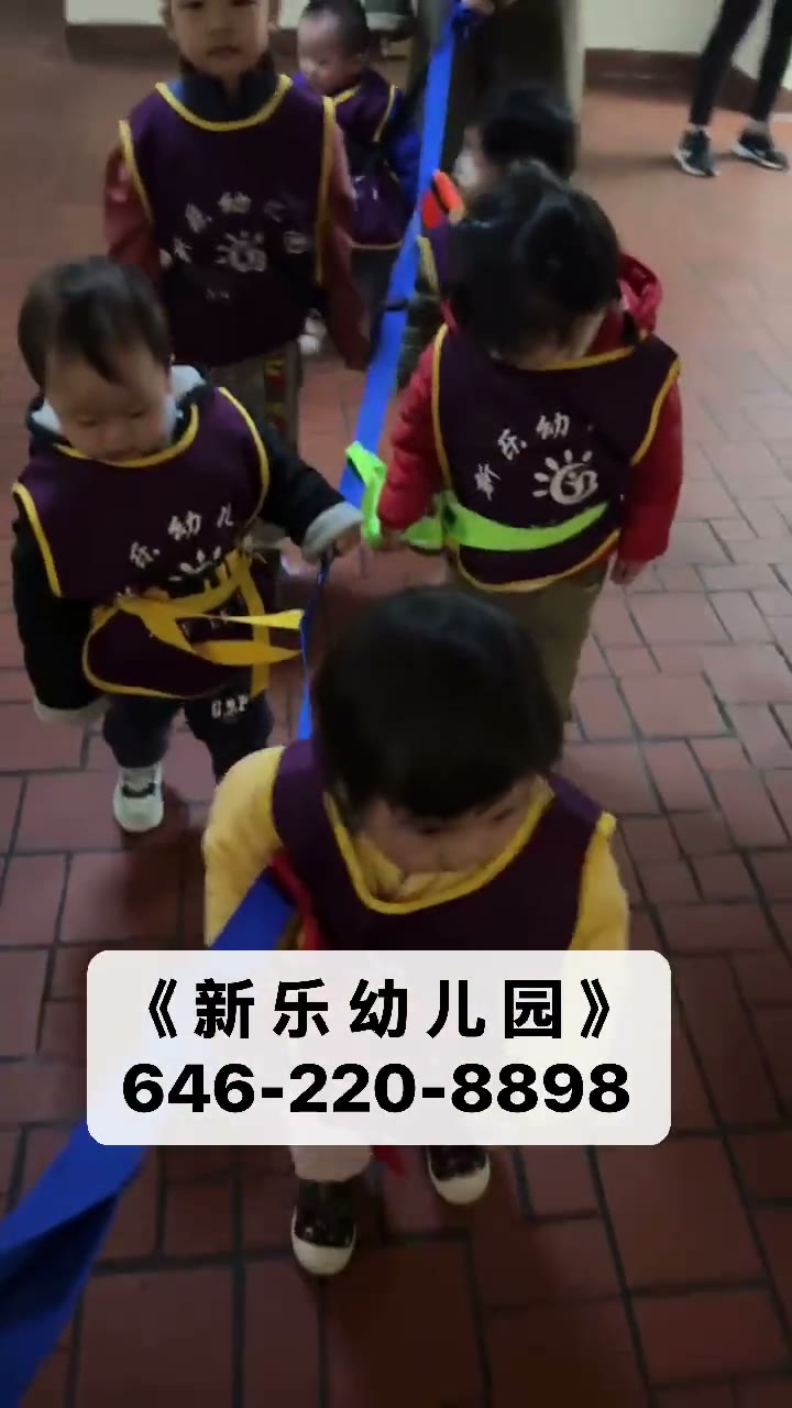 孩子们穿园所马甲牵绳排队进行列队活动